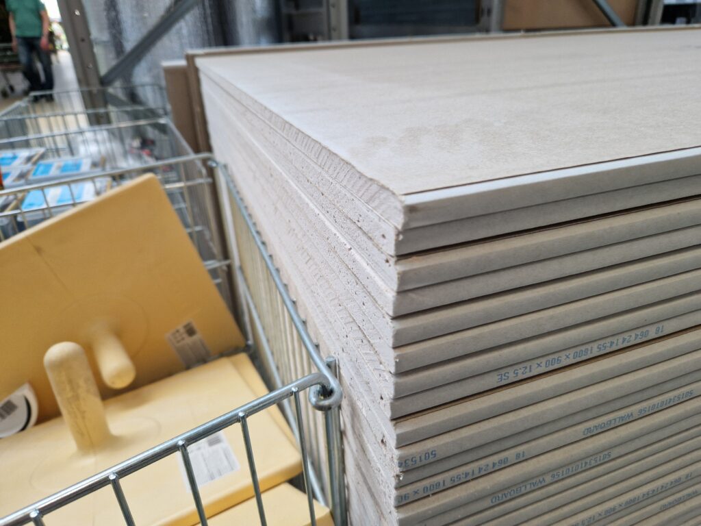 Drywall panels stacked in a London warehouse, ideal for construction projects